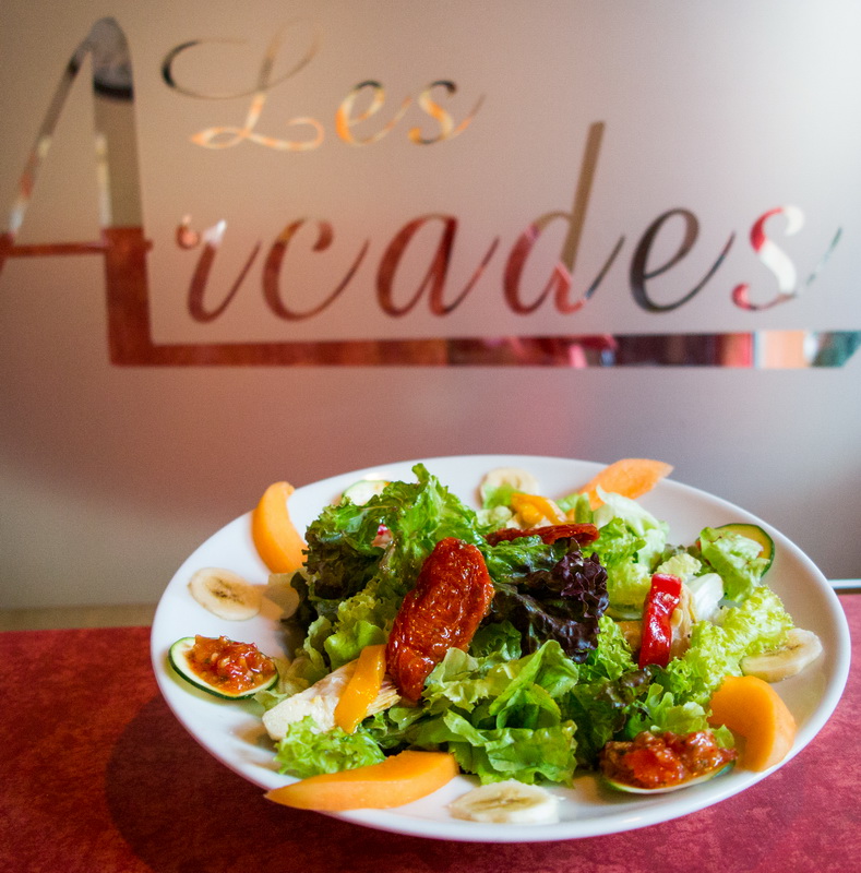 brasserie-arcades-qui-sommes-nous-004 salade au premier plan et Les Arcades en arrière plan